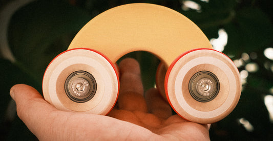 Hand held Chunkies wooden toy car called the rainbow with its oversized wheels, real skate bearings and arched shape for easy handling for smaller kids