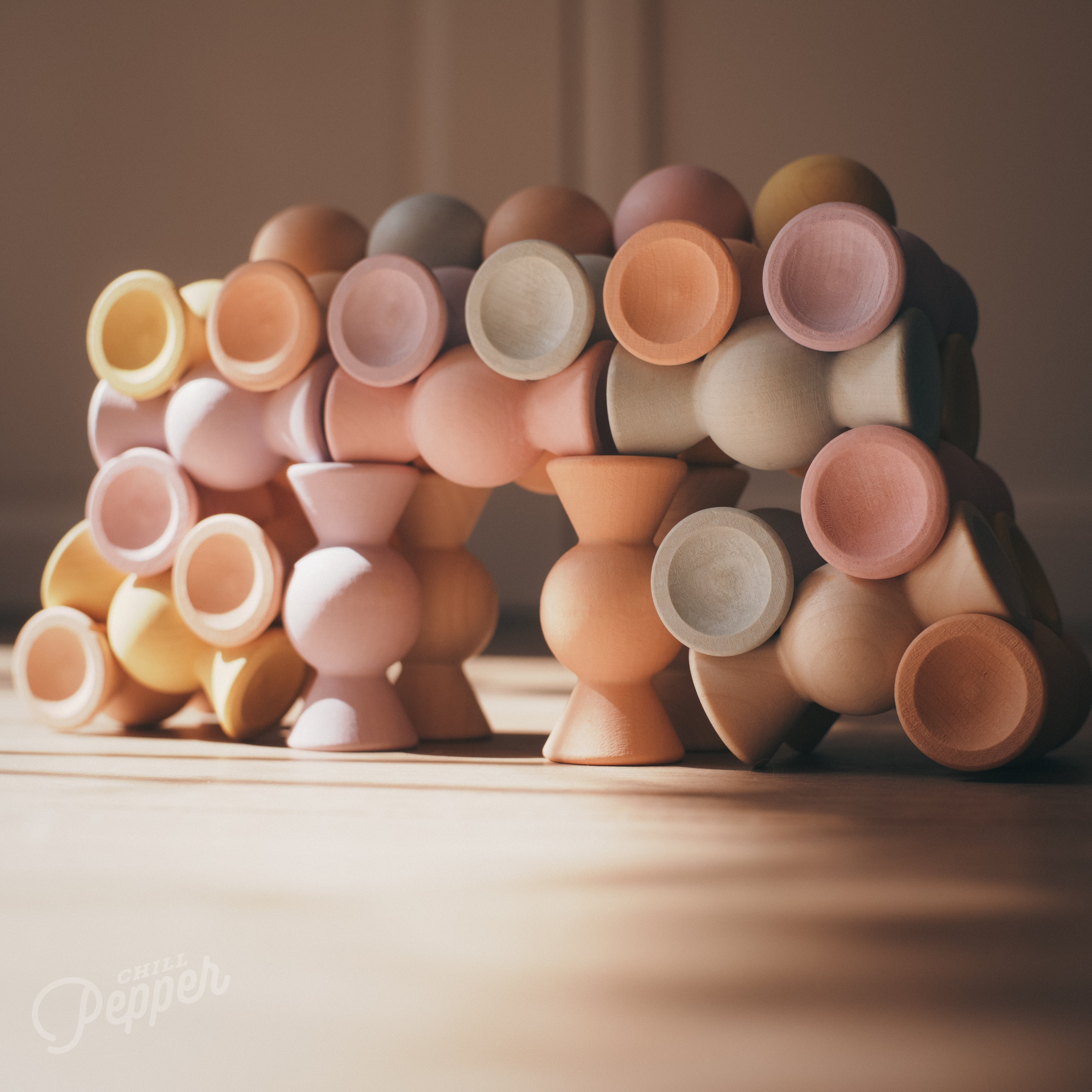 Chill Pepper Sweets stacked in a bridge with a blurry background. Made in Europe, shaped like candy. Great for stacking games and loose parts play